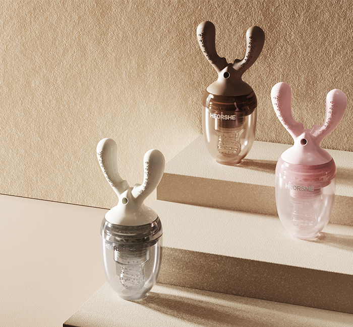 Three silicone baby teethers and mesh feeders on a light surface with a neutral background