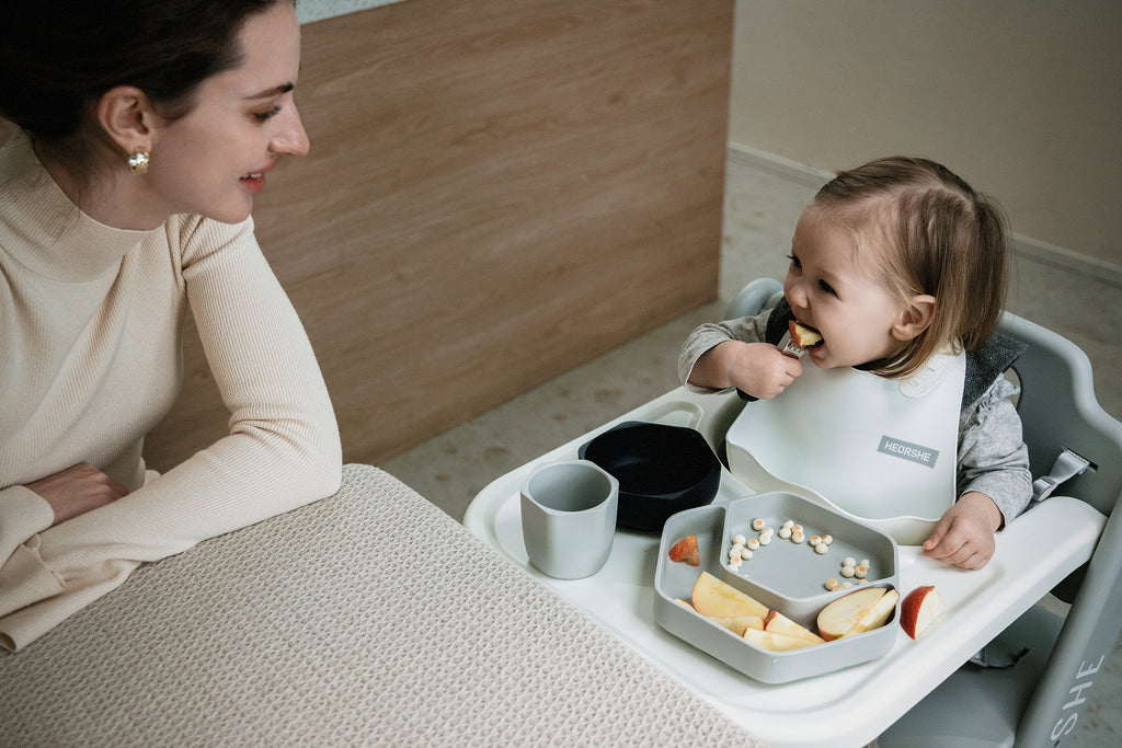 Woman and child at a dining table with food and utensils
