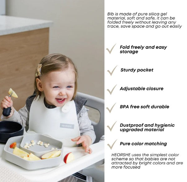 Child wearing a bib with a HEORSHE branded tray, sitting in a high chair with food.